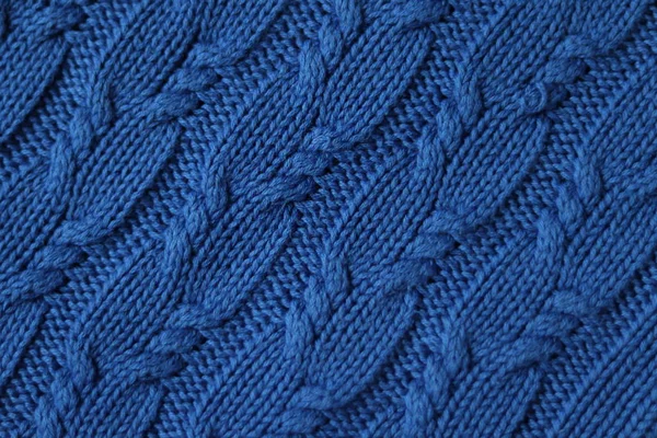 Seamless knitted fabric with pigtails. Knitted sweater, plaid, scarf. Knitted background. Classic Blue color 2020