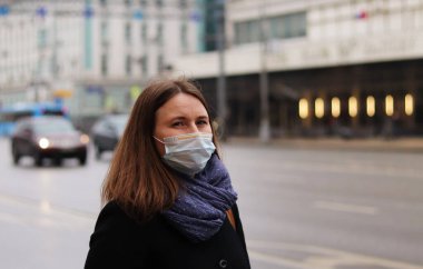 Koruyucu, tek kullanımlık tıbbi maskeli genç Avrupalı kadın. 2019-nCoV grip koronavirüsü konsepti Çin 'de mutasyona uğradı ve yayıldı.