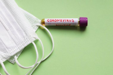 Coronavirus test tüpü ve beyaz koruyucu maskeler.