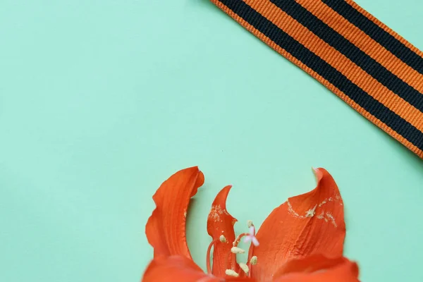 圣乔治丝带和橘红色百合花作为胜利日的背景 2020年5月9日 伟大卫国战争胜利75年 平面布局 复制空间 顶视图 图库图片