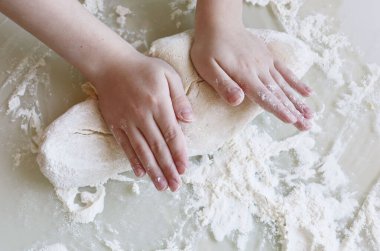 Undan hamur yapmak. Çocuk hamuru yakın plan yoğurur.