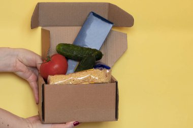 Coronavirus yemek teslimatı. Gönüllü bir kutu yiyecek getiriyor..