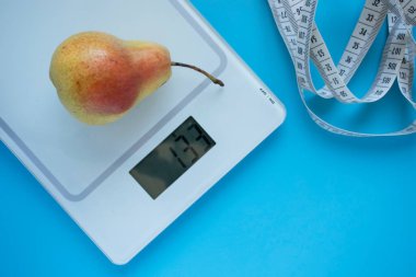 Armut, pullar ve mavi arka planda santimetre. Sağlıklı beslenme ve kilo verme kavramı. Kendini karantinaya al.
