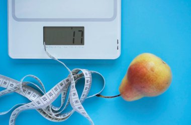 Armut, pullar ve mavi arka planda santimetre. Sağlıklı beslenme ve kilo verme kavramı. Kendini karantinaya al.