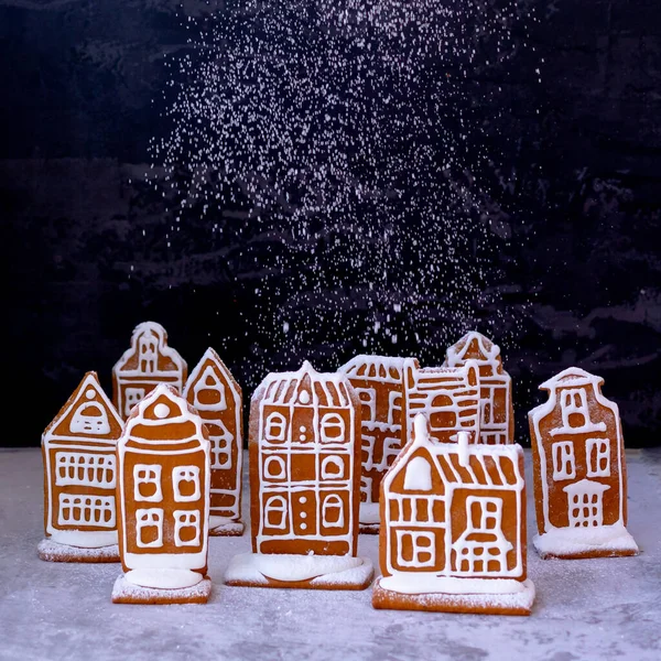 Little gingerbread houses with glaze standing on table