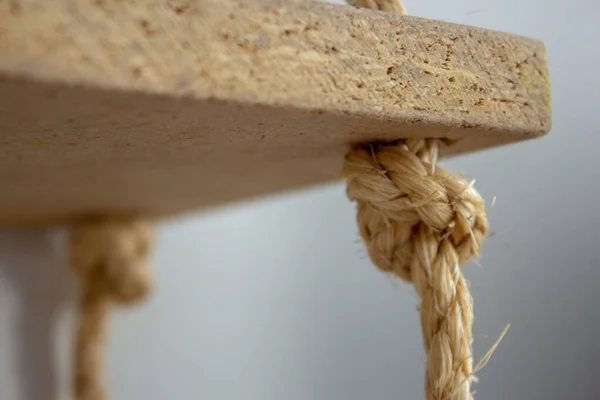 Sisal rope shelf made with old planks, closeup on the knot holding the shelf