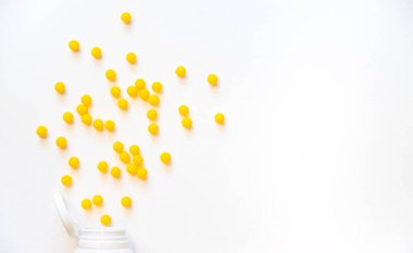Vitaminler beyaz arka planda sarı Dragee izolasyonu yapar. Seçici odak.