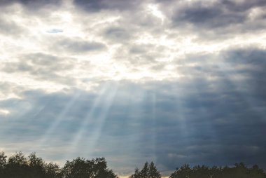 Güneş ışınları gökyüzündeki bulutların arasından geçiyor. Seçici odak.