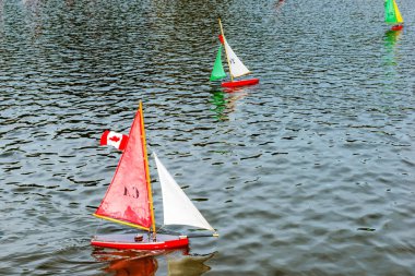 Lüksemburg Parkı 'ndaki bir çeşmenin etrafındaki havuzda çok renkli tekneler yüzüyor. Paris mi? Fransa.