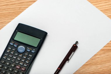 Tahta üzerinde beyaz kağıt olan endüstriyel hesap makinesi, çalışmaya hazır..