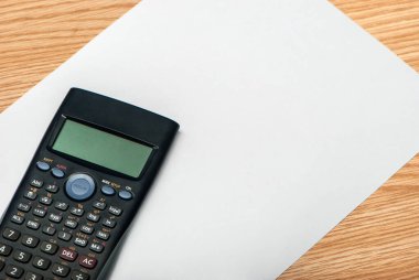 Tahta üzerinde beyaz kağıt olan endüstriyel hesap makinesi, çalışmaya hazır..