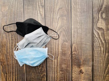 Farklı tip kullanılmış ve yeni koruyucu tıbbi maskeler ahşap masa. Hava kirliliği ve virüse karşı solunum koruma maskeleri.