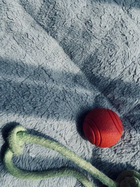 Kırmızı top ve ip yumuşak yatakta doğal ışıklandırma altında.