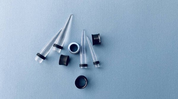 Tunnels and ear stretch tools in studio light. Tunnels are trendy especially for young generation.