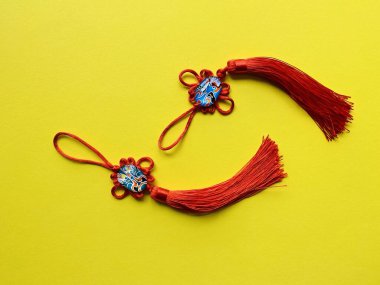 Sarı arkaplanda iyi şanslar dilemek için kırmızı Çin düğümleri ve kopya alanı. 