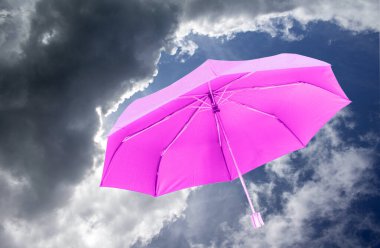 Gökyüzü zemininde pembe şemsiye