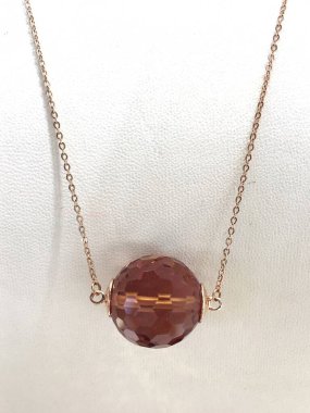 Hafif arka planda sultanit kolyesi olan altın bir zincir. Sultanit, farklı aydınlatma koşullarında renk değiştiren bir taştır..