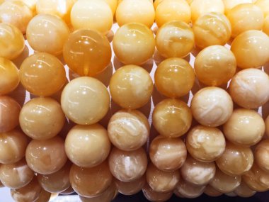 Yuvarlak Baltık kehribarından bilezikler. Bir kuyumcu posteri için.