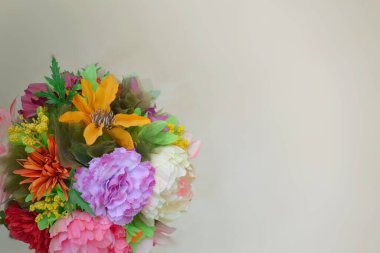 Tarafsız bir arkaplanda farklı çiçeklerden oluşan yuvarlak bir buket.