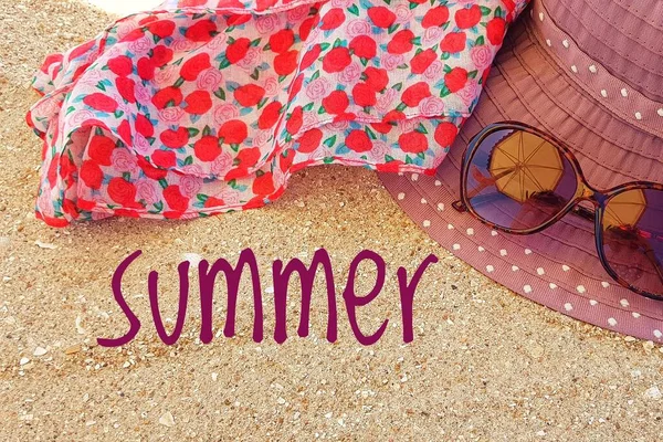 Čepice a sluneční brýle na písku s nápisem Léto. — Stock fotografie