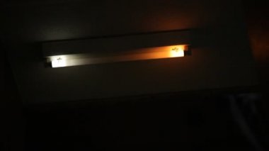 Kırık floresan ampulün titremesi ve yanıp sönmesi ürpertici apartman merdivenleri ve koridorun karanlığında. Parlak ışıklar karanlık gece sahnesini aydınlatıyor..