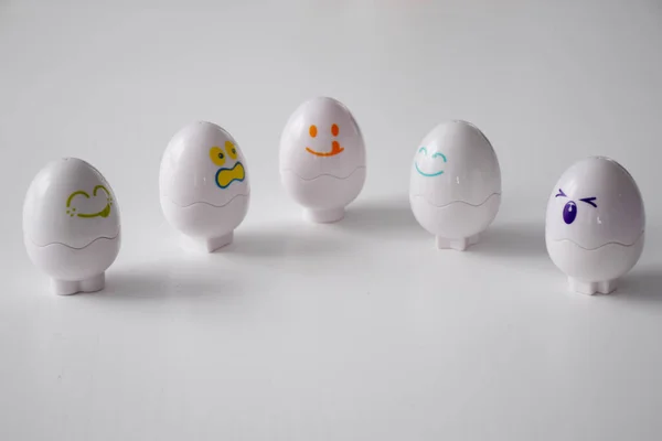 Funny emotional eggs on white table