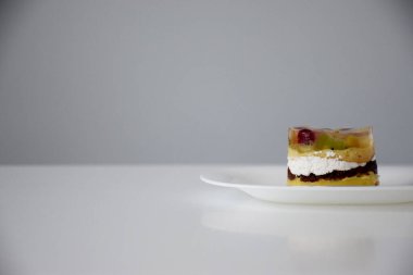 Beyaz tabakta meyveli ve kremalı pasta.