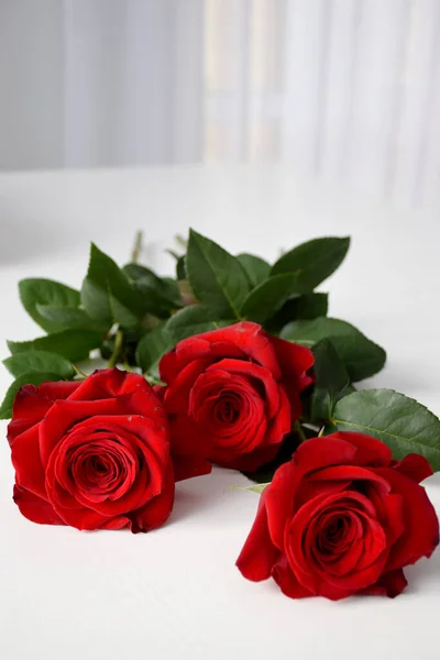 Τρία Κόκκινα Τριαντάφυλλα Λευκό Τραπέζι Στο Σπίτι Φως — Φωτογραφία Αρχείου