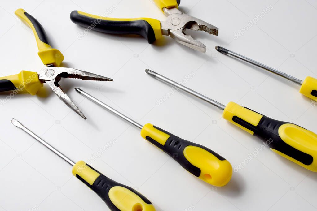 Black and yellow working tools, pliers, wire cutters andscrewdrivers which can be used to repair, build, improve, fix. Competition, fight, combat, battle, aggressive