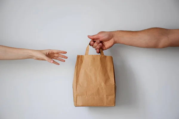 Kurye bir müşteriye kağıt paket verir. Çevrimiçi alışveriş veya dağıtım hizmeti kavramı