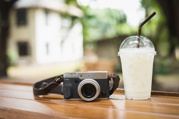 Vintage-Kamera mit Eiskaffee auf Holztisch — Stockfoto