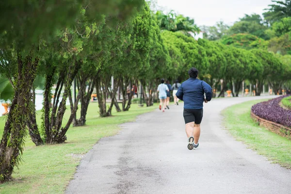 fat man jogging at public park