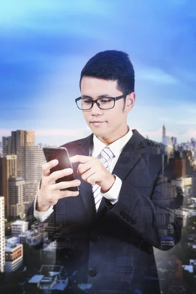 Бізнесмен перевіряє електронні листи по телефону, міському фону — стокове фото