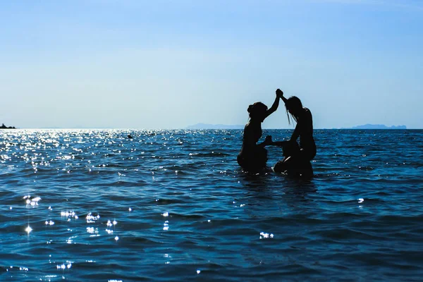 Silhouette Bild Gruppe junge Leute spielen auf dem Meer — Stockfoto