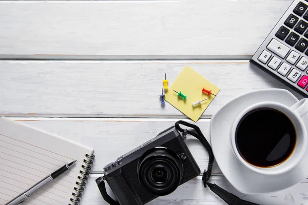 Kávé, kamera és a fehér fa-ba jegyzetfüzet felülnézeti képe — Stock Fotó