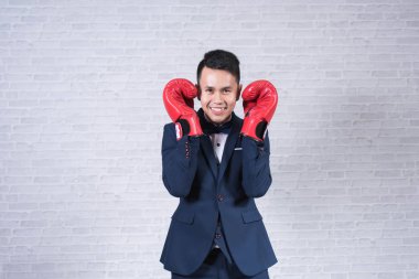 takım elbise ve boks eldivenleri gri arka plan üzerinde giyen adam
