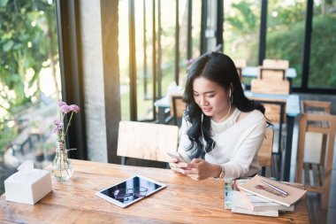 Cep telefonuyla kafede Asya kız