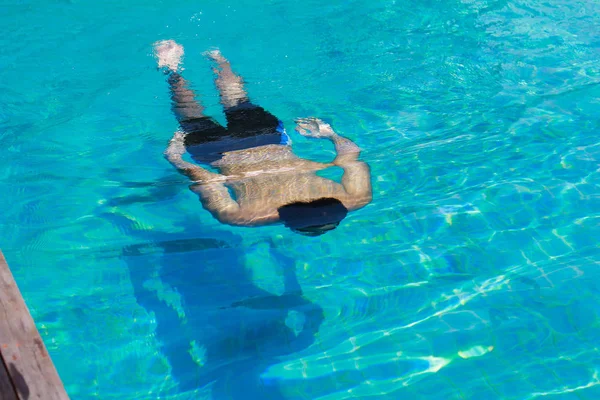 Молодой человек плавает в открытом бассейне — стоковое фото