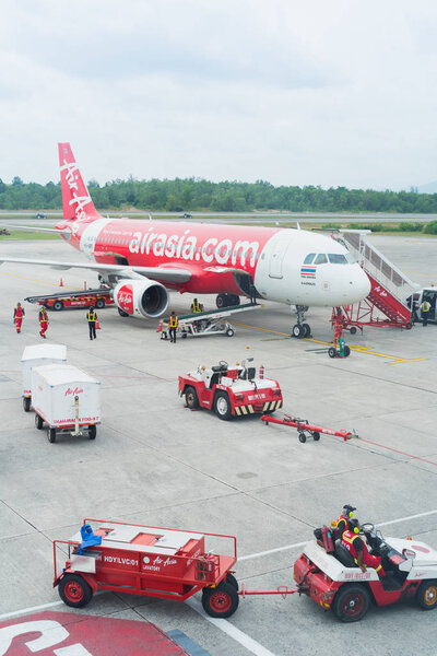 CHIANG RAI, THAILAND - 17 октября 2016 года: разгрузка багажа с самолета Air Asia в аэропорту Бангкока 17 октября 2016 года. Авиакомпания Air Asia - крупнейшая бюджетная авиакомпания Азии
