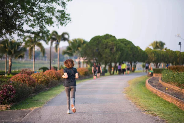 Kvinna som jogging i trädgården på kvällen — Stockfoto