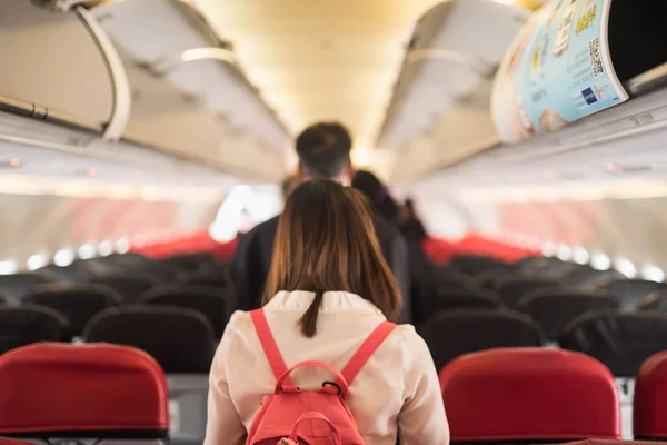 Самолет чианг рай, Тайланд - 11 декабря 2017 года: Салон самолета Air asia с пассажирами, сидящими на сидениях, и стюардесса, идущая к алтарю на заднем плане — стоковое фото