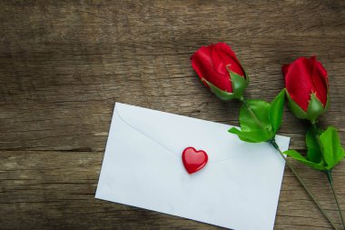 kırmızı gül ve ahşap masa harfinde yakın çekim