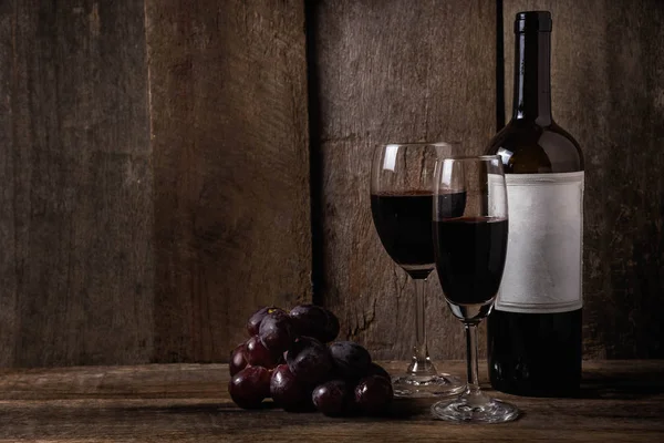 Vino e uva su fondo tavola in legno — Foto Stock