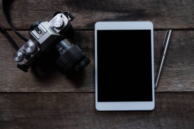 tablet ve ahşap arka plan üzerinde kamera düz lay