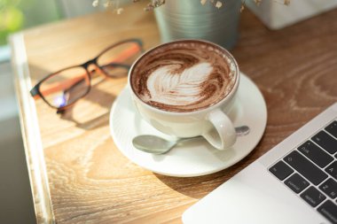 Kahve sanatı, not defteri ve bardaklar kafedeki ahşap masada.