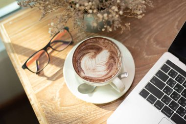 Kahve sanatı, not defteri ve bardaklar kafedeki ahşap masada.