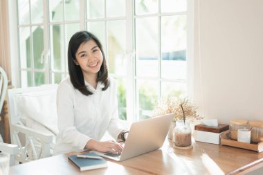 Kadınlar masada dizüstü bilgisayar kullanarak çalışıyor. Kafede bazı fikirlere kapılıyorlar.