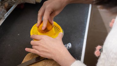 Kadınlar masada portakal suyu yapıyor.