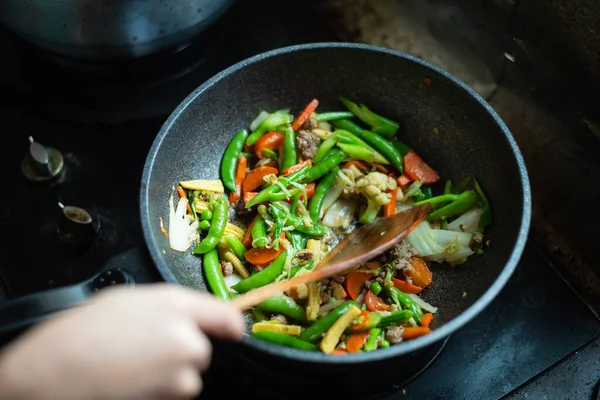 Cerrar las verduras fritas en la sartén en la cocina —  Fotos de Stock