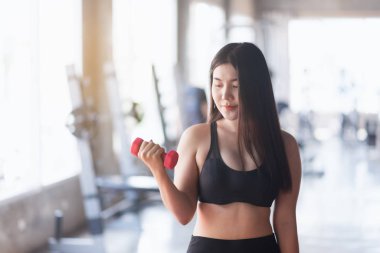 Spor salonunda halterle spor yapan kadınlar.